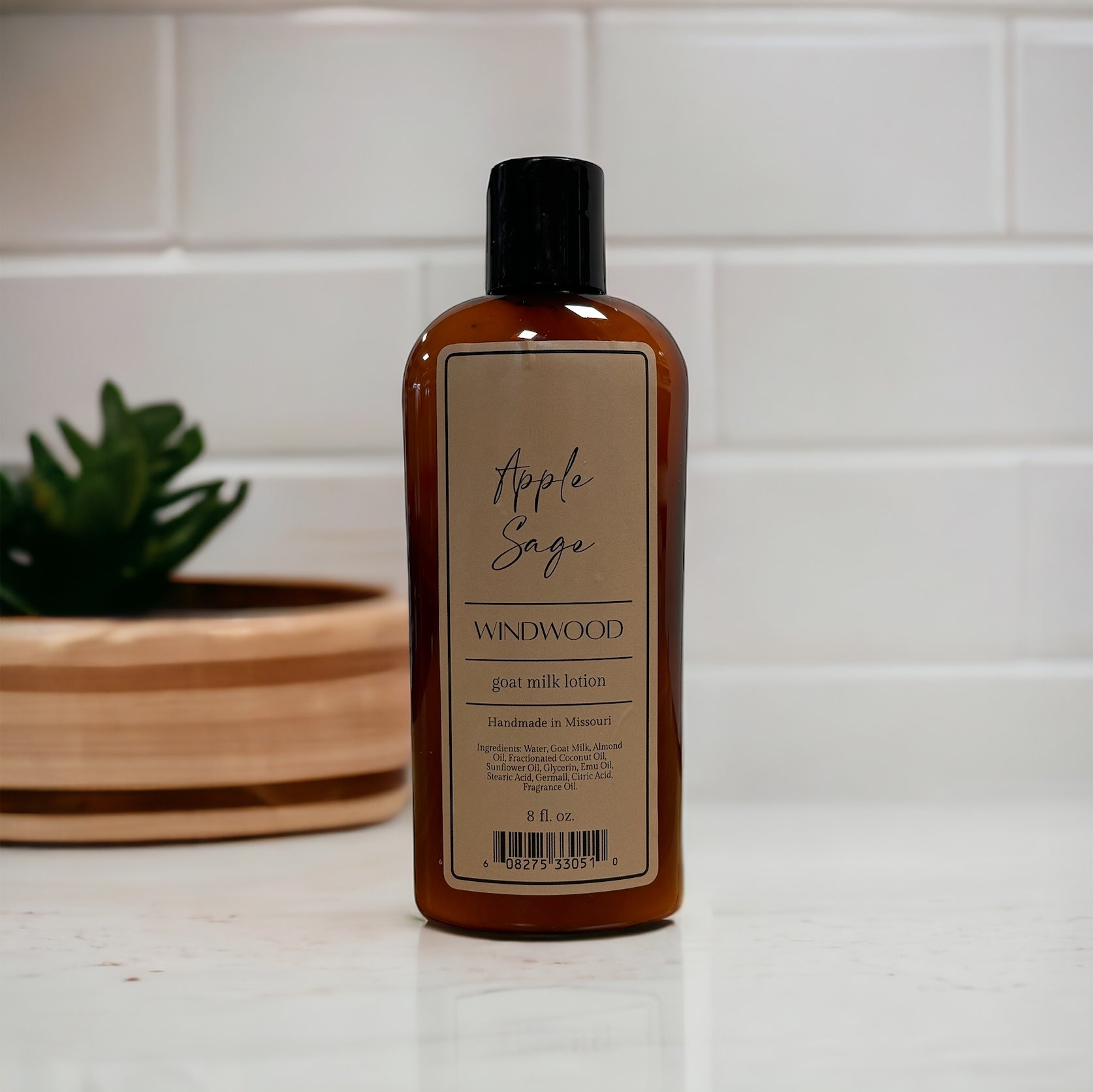 A brown bottle of lotion on a countertop with a plant in the background.